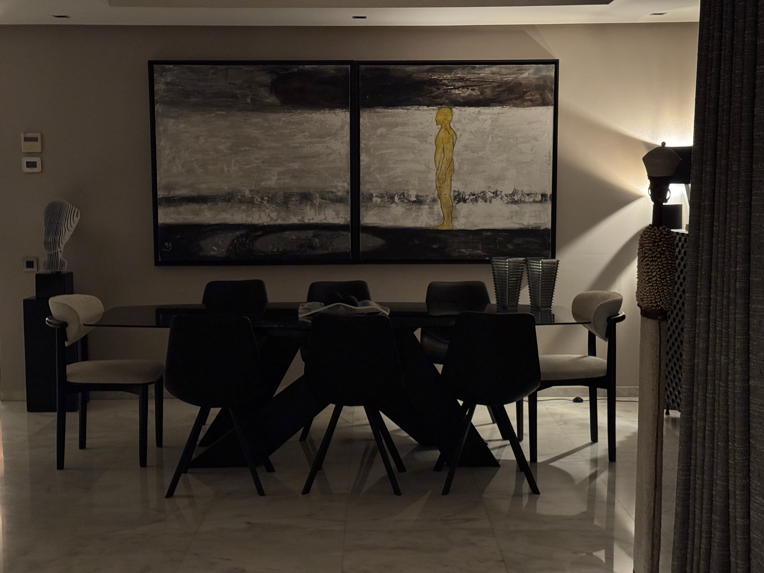 Coin lecture avec fauteuil noir, bibliothèque en bois et lampadaire