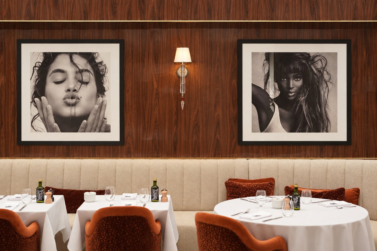 Photographies encadrées et tables dressées au restaurant LANA