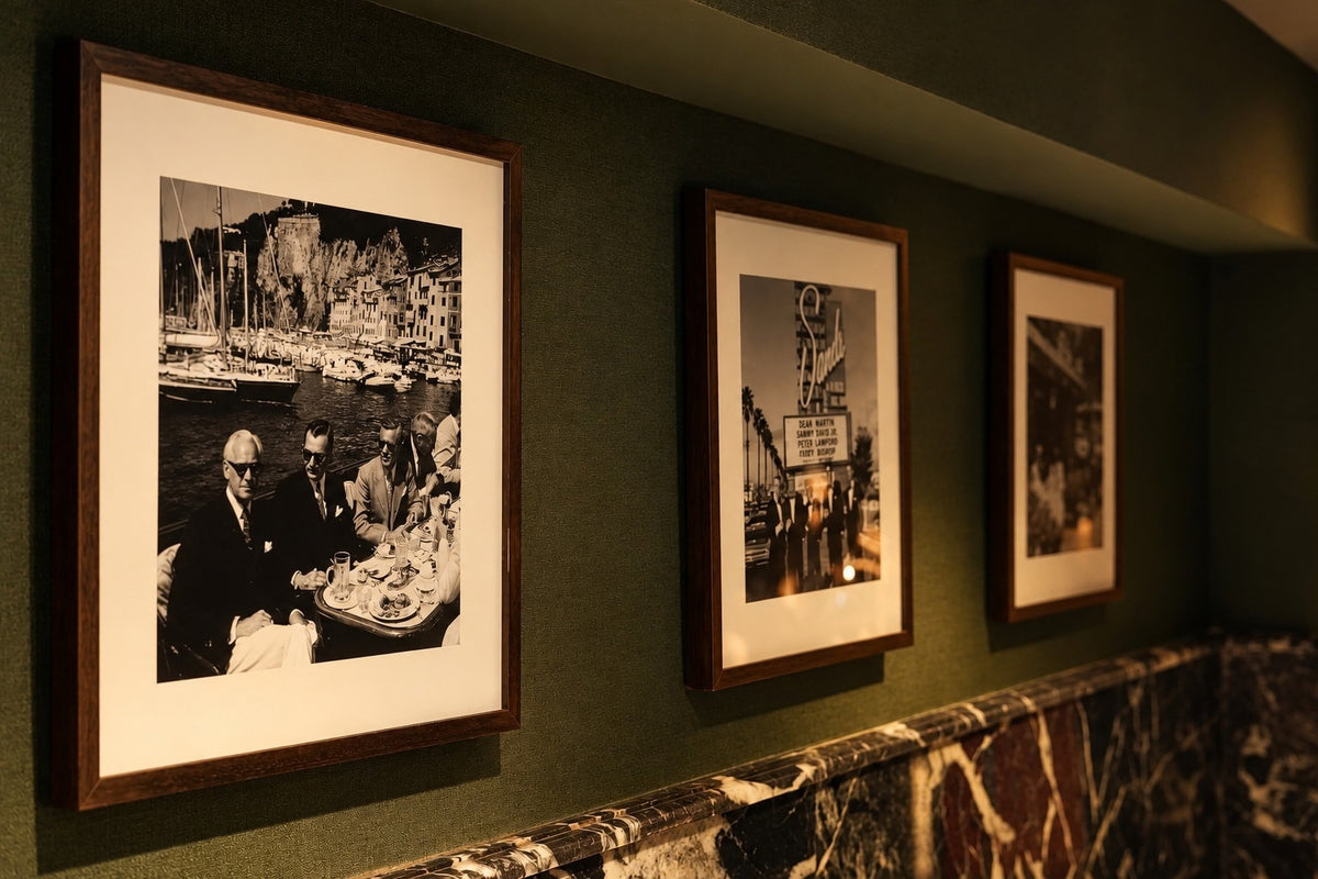 Série de photographies en noir et blanc sur un mur vert du restaurant LANA
